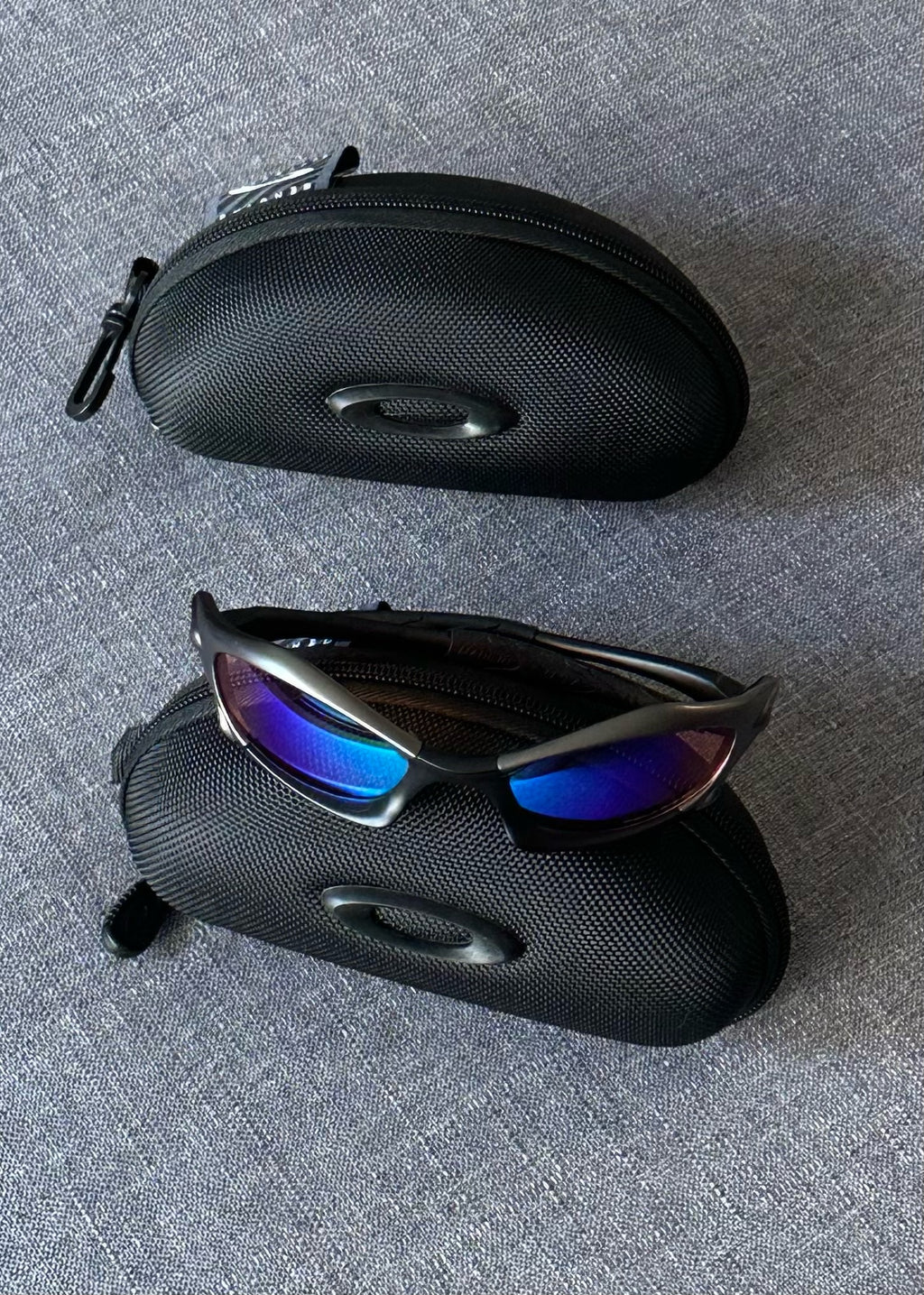 Óculos de sol Oakley vintage: armação carvão, lentes espelhadas Iridium azul–roxo com estojo
