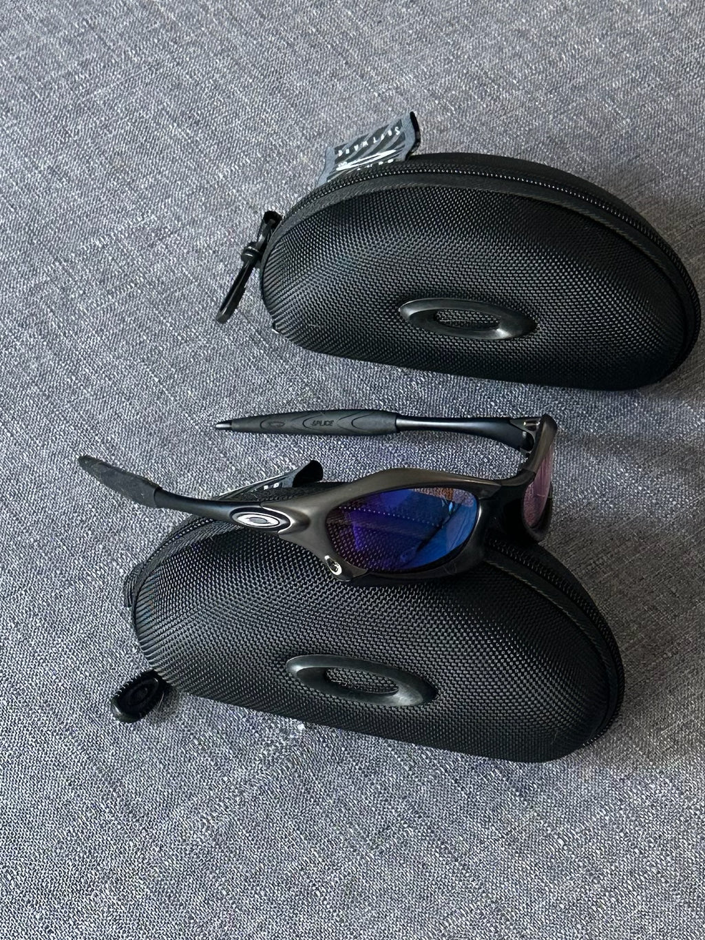 Óculos de sol Oakley vintage: armação carvão, lentes espelhadas Iridium azul–roxo com estojo
