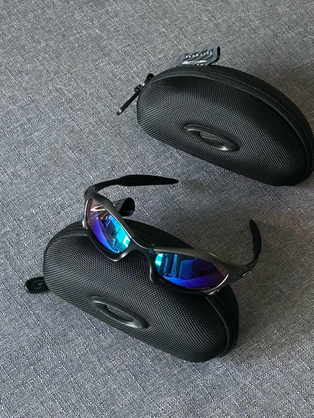Óculos de sol Oakley vintage: armação carvão, lentes espelhadas Iridium azul–roxo com estojo
