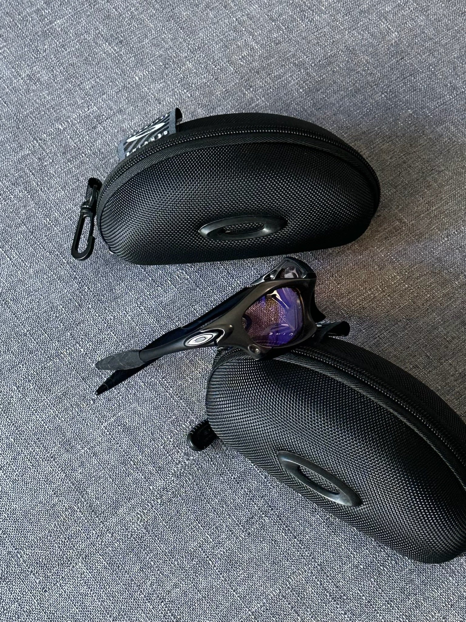 Óculos de sol Oakley vintage: armação carvão, lentes espelhadas Iridium azul–roxo com estojo
