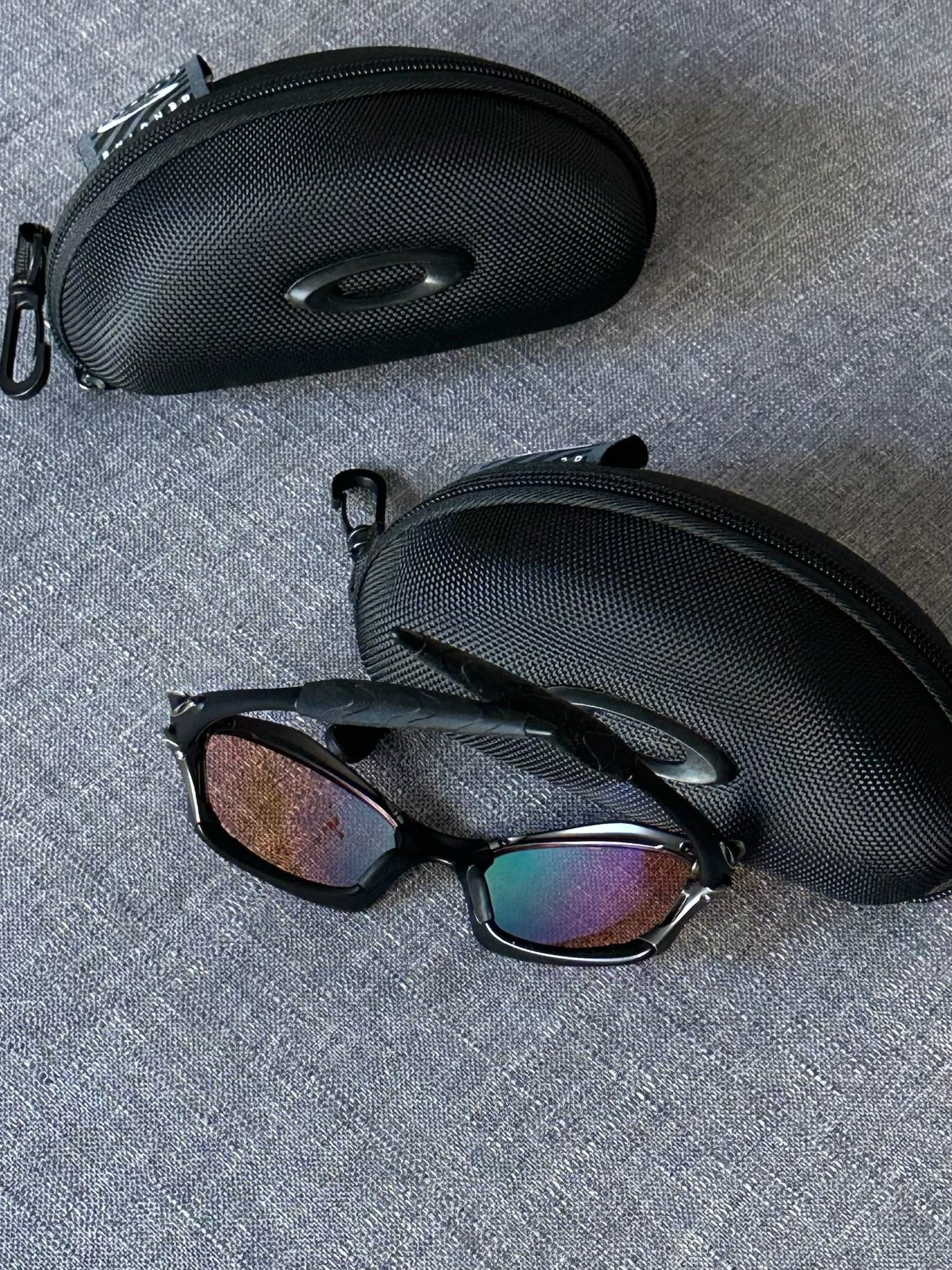 Óculos de sol Oakley vintage: armação carvão, lentes espelhadas Iridium azul–roxo com estojo
