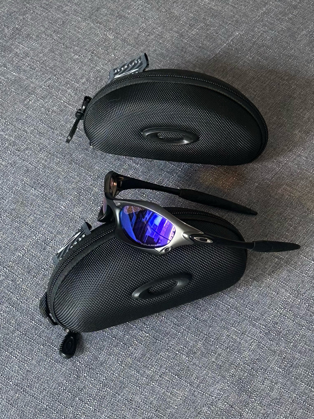Óculos de sol Oakley vintage: armação carvão, lentes espelhadas Iridium azul–roxo com estojo
